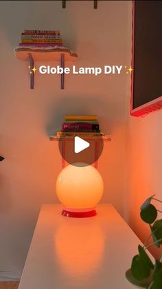 the globe lamp diy is on top of a table next to a potted plant