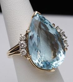 Pear Cut Blue Topaz with Side Diamond Flair Ring 14K Yellow Gold Size US 5 1/4 Weight: 13.4 grams Blue Topaz measures approx 23 mm tall x 14.8mm wide (approx 21.8ct) Topaz is approximately VS quality Round Diamonds: approx 1/2 cttw Diamond Color: approx H-I Diamond Clarity: approx VS2-SI1 Head of Ring measures approx 22 mm wide x 25.8mm tall This is a pre-owned item in Good Condition. It does show signs of use/wear but there is still lots of life left to this ring. Topaz has some chips at the fa Pear Cut, Diamond Clarity, Blue Topaz, Rings Statement, Round Diamonds, Pear, Colored Diamonds, Topaz, Statement Rings