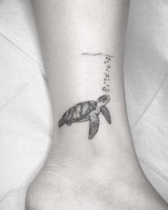 a small turtle tattoo on the ankle with bubbles coming out of its mouth and head