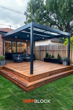 a wooden deck in the middle of a yard with an attached pergolan roof