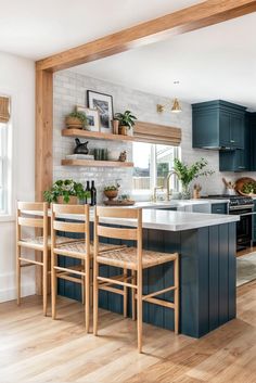 a kitchen with blue cabinets and wooden floors is seen in this image from the dining room