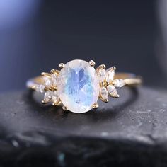 a ring with an oval rainbow colored stone surrounded by small white diamonds