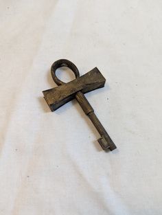 an old key is laying on a white sheet