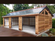 a large wooden garage with two doors and windows