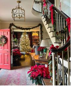 christmas decorations are on display in the entryway to this elegantly decorated home, which is decorated with poinsettis and greenery