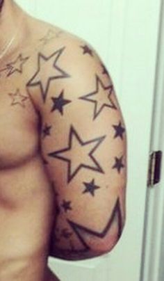 a shirtless man with stars on his arm and chest is taking a selfie