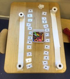 a wooden table topped with lots of different types of letters and numbers next to rolls of tape