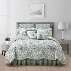 a bed with green and white comforters in a room