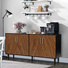 a coffee bar with two shelves above it and flowers on the table next to it