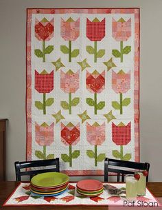 a table topped with a quilt and plates