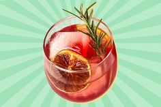 a drink with orange slices and rosemary garnish in a glass on a green background