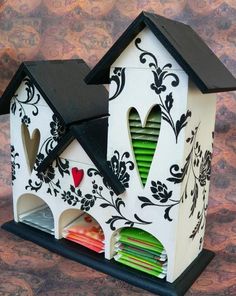 a white and black bird house with green shutters