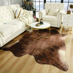 a living room filled with white furniture and a brown cowhide rug on top of a hard wood floor