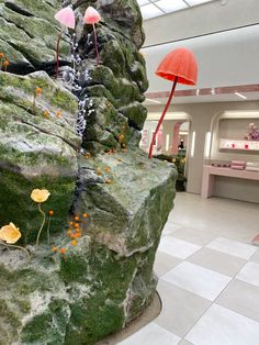 the interior of a store with fake rocks and flowers