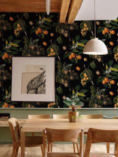 a dining room with a table and chairs next to a wall covered in fruit print