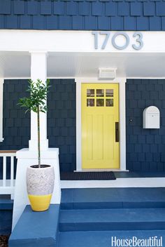 a yellow front door on a blue house