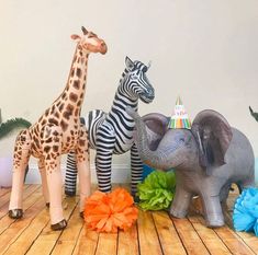 two zebras, an elephant and a giraffe on a wooden floor