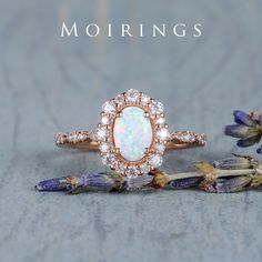 an opal and diamond ring sits on top of lavenders