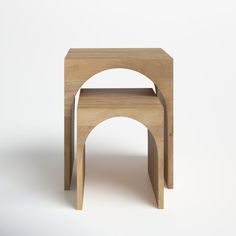 two wooden stools sitting side by side in front of a white wall and floor