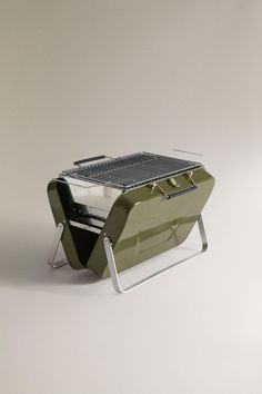 an outdoor grill sitting on top of a metal stand