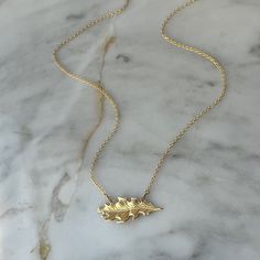 This necklace features a solid brass oak leaf pendant gracefully suspended on a 14k gold fill chain. The oak leaf's timeless design and warm brass hue offer a touch of natural charm. With a clean and minimalist aesthetic, the necklace embraces simplicity, allowing the intricate details of the oak leaf to shine. The 14k gold fill chain adds a hint of elegance, creating a seamless fusion of classic and contemporary style. Durable and versatile, this necklace is a celebration of the enduring beauty found in the simplicity of nature. ● 16" Chain ● 14k Gold fill chain ● Solid Brass Oak Leaf Oak Leaf Necklace, Oak Leaf, Women's Jewelry And Accessories, Leaf Necklace, Leaf Pendant, Minimalist Aesthetic, Gold Filled Chain, Language English, Intricate Details