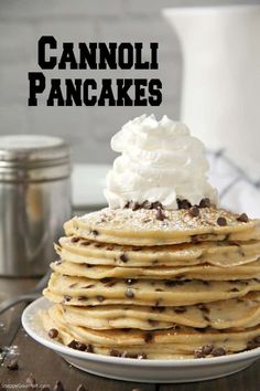 a stack of pancakes topped with whipped cream and chocolate chips