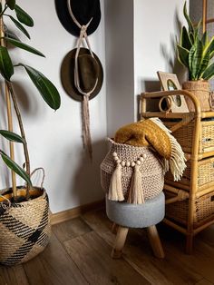 a chair with a blanket on it next to some potted plants and other items