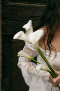 a woman in a white dress holding flowers