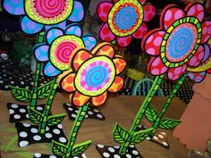 colorful paper flowers are on display at a craft store with polka dot dots around them