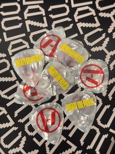 several plastic bags with yellow and red stickers on them sitting on a black surface