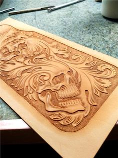 an intricately carved wooden plaque with a skull on it