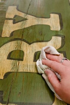 a person is wiping down the wood with a cloth