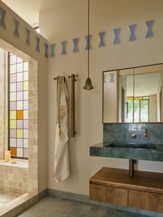 a bathroom with a sink, mirror and towel rack