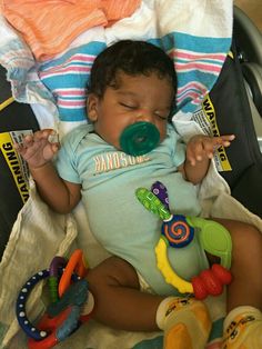 a baby laying in a stroller with pacifier