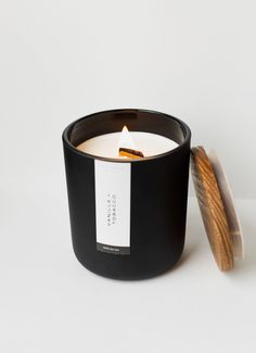 a black candle with a wooden lid next to it