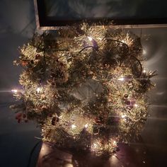 a christmas wreath is lit up with lights