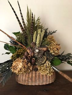 a basket filled with lots of different types of flowers and plants on top of a wooden table