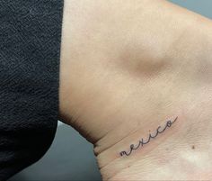 a woman's wrist with the word mom written in cursive writing on it