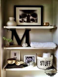 a shelf with pictures and other items on it in a room that has been decorated by pinter