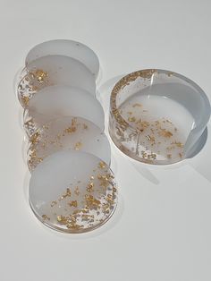 six white dishes with gold sprinkles on them sitting next to each other