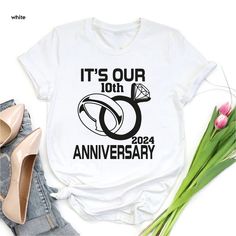 "Its Our 10th Anniversary 2024 Shirt,Anniversary Gift For Couples Shirt,Matching Anniversary Shirt,10th Wedding Anniversary Gift,Couples Gift 🎈HOW TO ORDER 1-) Please, check and review all the photos. 2-) Choose your t-shirt size and color. *Different styles of shirts may have different shades of same color choice due to different manufacturer brands. *For this reason, we recommend you to match shirts from the same styles if you want precisely matching colors (ex. Unisex, V-necks, Toddler, etc.). 3-) Click add to cart. You can go back to add more shirts. 4-)Click \"Proceed to check out\". 5-)When you check out, you can add a note to seller for any request. 🎈PRODUCT DESCRIPTION UNISEX SHIRTS * Unisex t shirt fits like a well-loved favorite, featuring a crew neck, short sleeves and designe 10 Year Anniversary Shirts, White Graphic Print Shirt For Anniversary, White Graphic Print Top For Anniversary, Anniversary Crew Neck Shirt With Graphic Print, Anniversary Graphic Print Crew Neck Shirt, White Letter Print Shirt For Anniversary, Summer Anniversary Graphic Print Tops, White Graphic Print Shirt For Wedding, Anniversary Crew Neck Top With Graphic Print