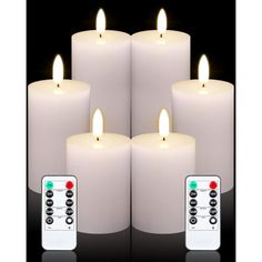 four white candles with remote controls in front of them