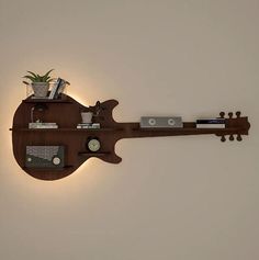 a guitar shaped shelf is mounted to the wall