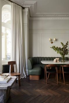 a living room filled with furniture next to a table and window covered in drapes