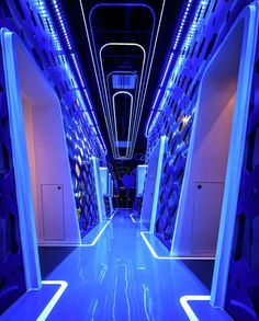 the inside of a vehicle with blue lights and white walls on either side of it