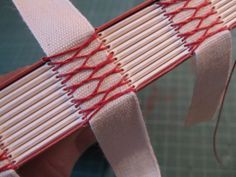 a close up of a person's hand holding a pair of scissors with red and white strips on them