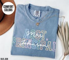 a blue t - shirt with the words act principals printed on it next to some feathers