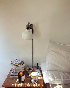 a nightstand with a lamp and books on it