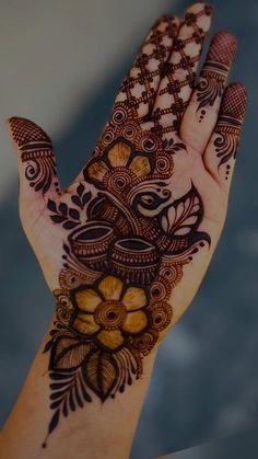 a person's hand with henna tattoos on it