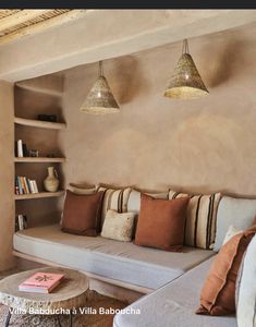 a living room filled with lots of furniture next to a wall mounted bookshelf